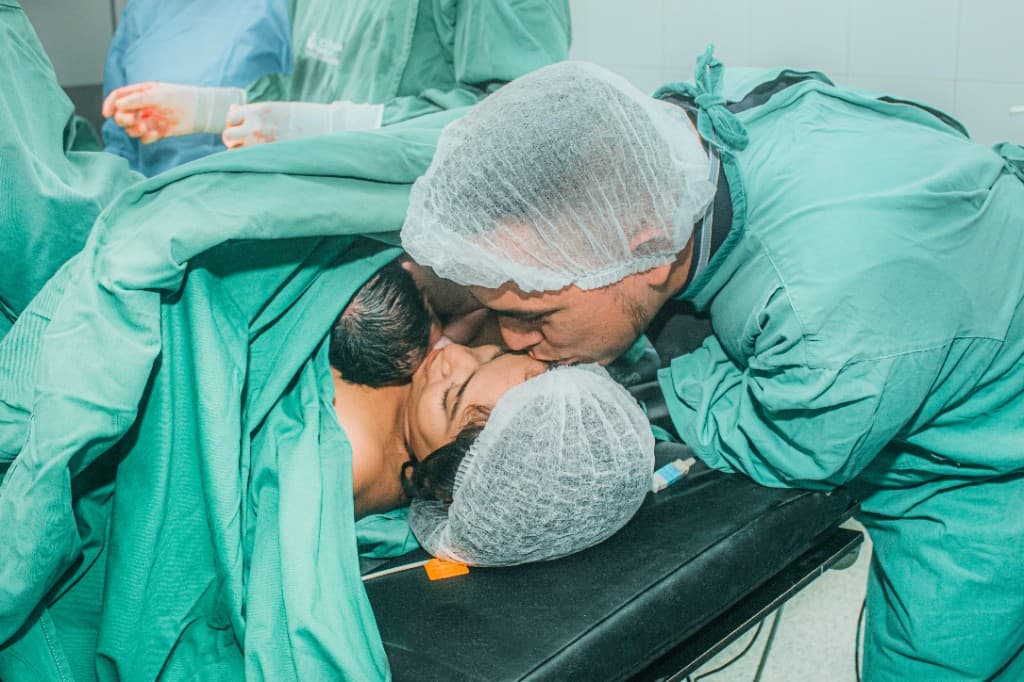 Papá besando a mamá durante nacimiento humanizado en NeoSer